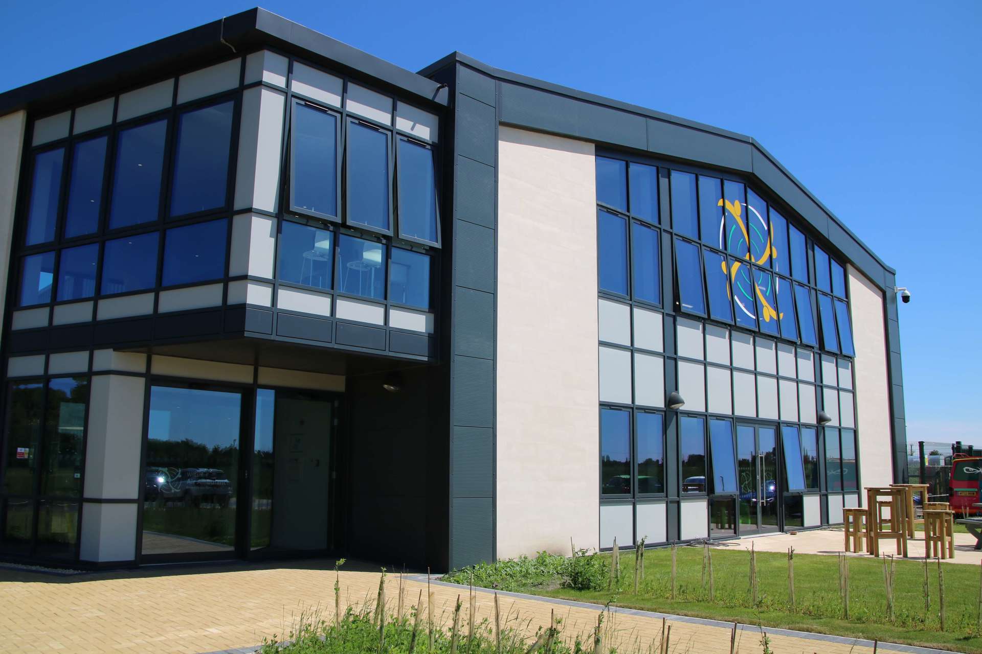 A photo of the front aspect of the Wiltshire Air Ambulance airbase against a sunny blue background.