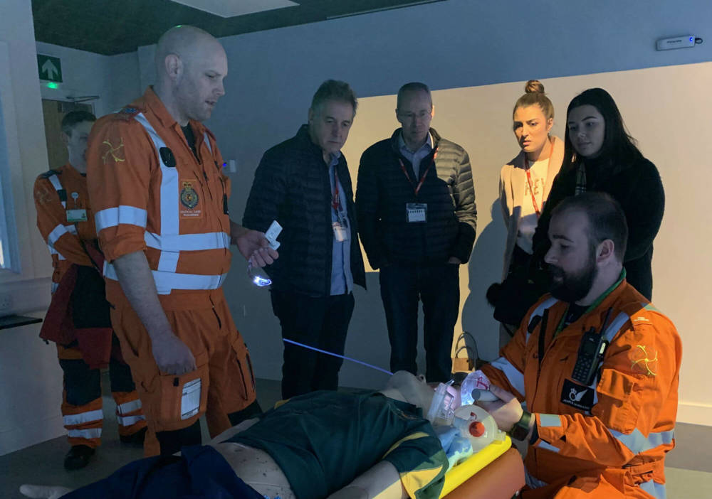 Two paramedics giving demonstrations to visitors inside the charity's iSim training facility.