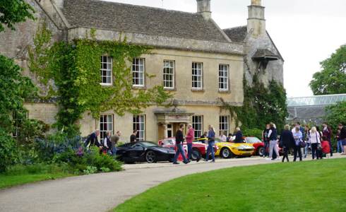 A photo of Middlewick House with sports cars parked outside and visitors taking photos and looking at the cars.