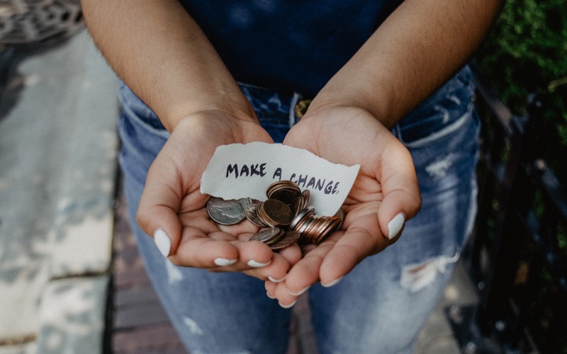 A small handwritten note stating 'make a change' with a variety of coins.