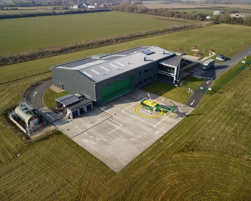 A drone shot over an air ambulance airbase, with helicopter on helipad