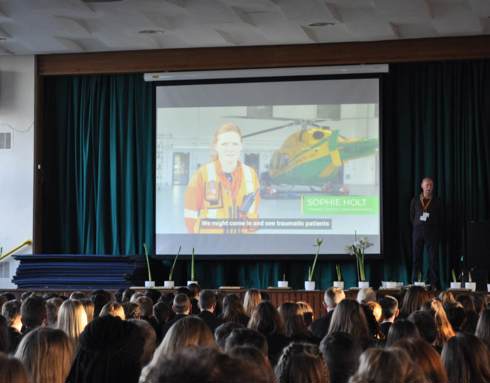 A volunteer delivering a talk at a school