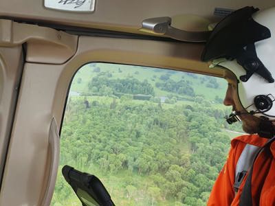 Dr Jono Holme admiring the view of green fields and tress from the Wiltshire Air Ambulance helicopter