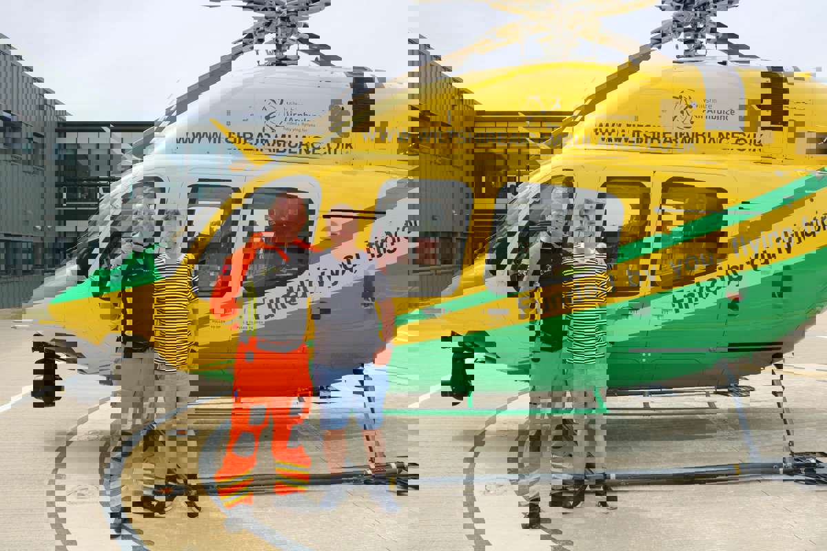 A former patient meeting critical care paramedic at the charity's airbase. They are stood in front of the helicopter on the helipad. A former patient meeting critical care paramedic at the charity's airbase. They are stood in front of the helicopter on the helipad.