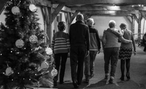 Black and white photo of family comforting each other with their backs to camera.