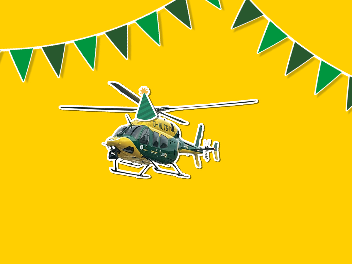 A yellow background with a sticker of the yellow and grey Bell 429 helicopter wearing a cartoon sticker hat, with green bunting around it A yellow background with a sticker of the yellow and grey Bell 429 helicopter wearing a cartoon sticker hat, with green bunting around it