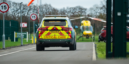 Wiltshire and Bath Air Ambulance's critical care car driving down the drive with the helicopter in view Wiltshire and Bath Air Ambulance's critical care car driving down the drive with the helicopter in view