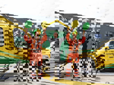 Paramedic Rich Miller wearing a yellow and green curly wig and holding yellow and green balloons, Rob Backus holding yellow Team WAA cheer sticks and Craig Wilkins wearing a yellow and green mohawk wig and holding yellow and green balloons Paramedic Rich Miller wearing a yellow and green curly wig and holding yellow and green balloons, Rob Backus holding yellow Team WAA cheer sticks and Craig Wilkins wearing a yellow and green mohawk wig and holding yellow and green balloons