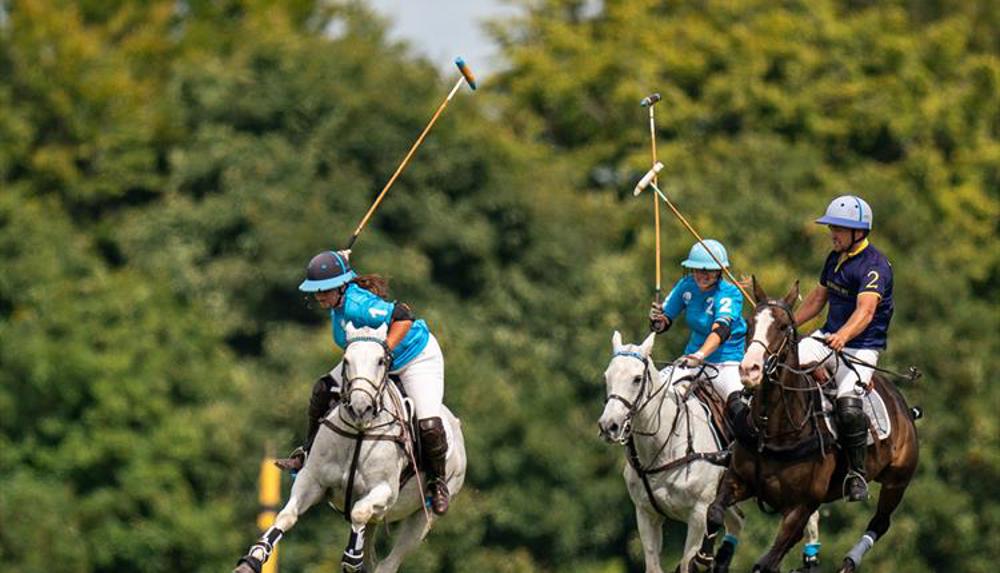 A group of three people playing polo at Stonehenge Polo Festival