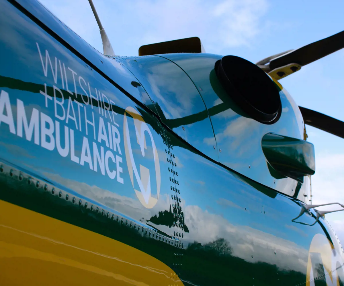 Wiltshire and Bath Air Ambulance helicopter showing logo and rotor blades