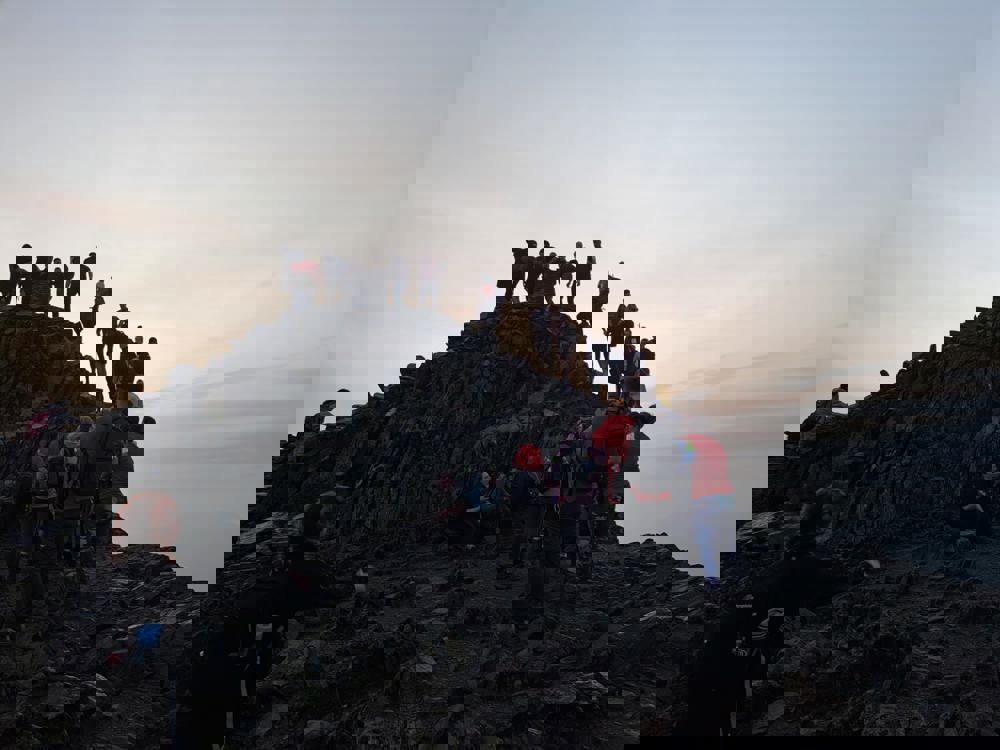 A photo of people climbing Mount Snowdon as the sun rises