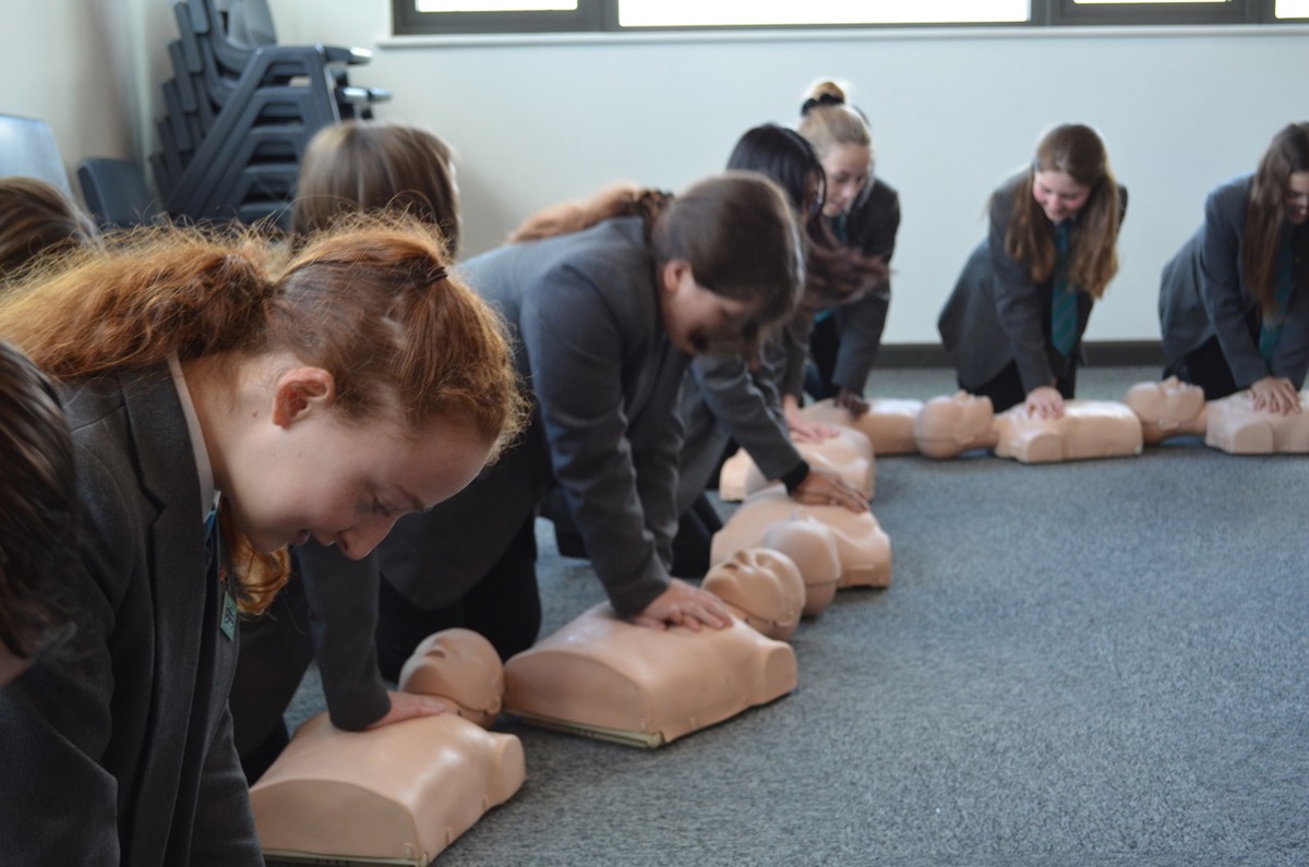 School children practicing CPR on a manekin