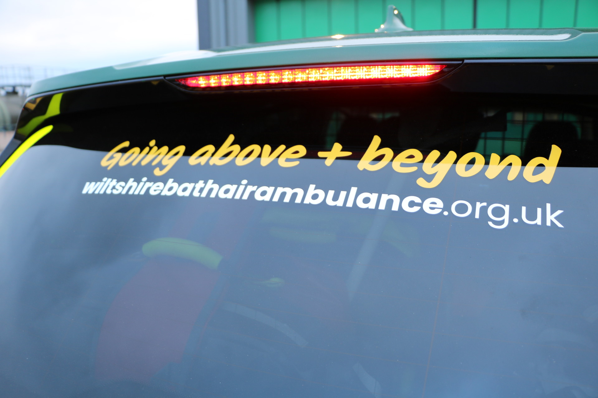 Going above + beyond strap line on the back of a car Going above + beyond strap line on the back of a car