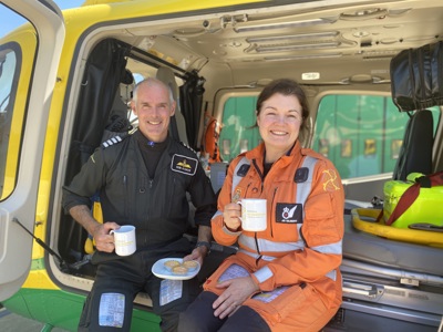 Pilot Rob and paramedic Jo posing with cakes and mugs whilst sat in Wiltshire Air Ambulance's helicopter Pilot Rob and paramedic Jo posing with cakes and mugs whilst sat in Wiltshire Air Ambulance's helicopter