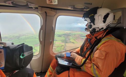 A critical care doctor in an air ambulance, looking out the window to see a rainbow A critical care doctor in an air ambulance, looking out the window to see a rainbow
