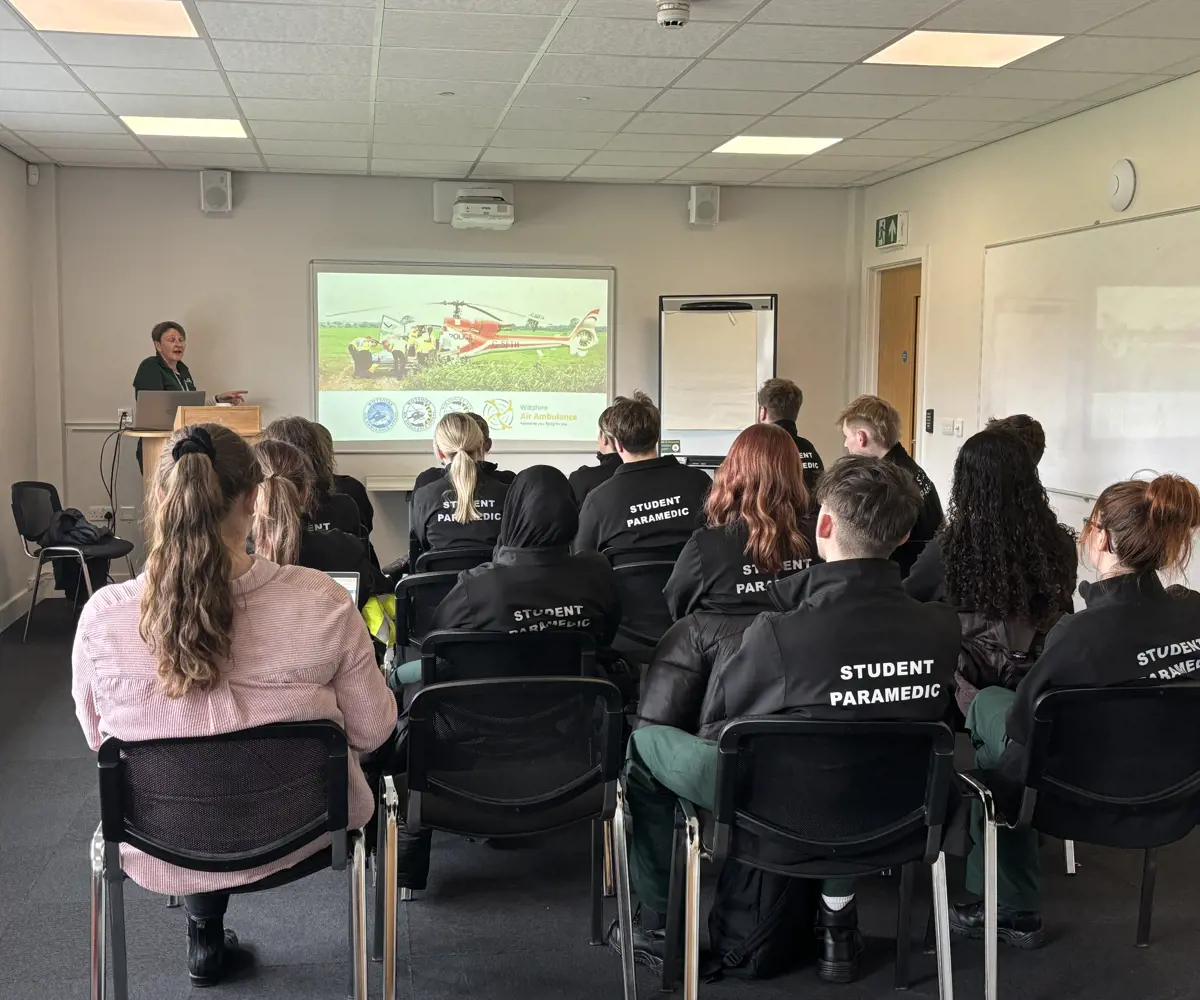 A group of student paramedics sat in seats, looking at a projection