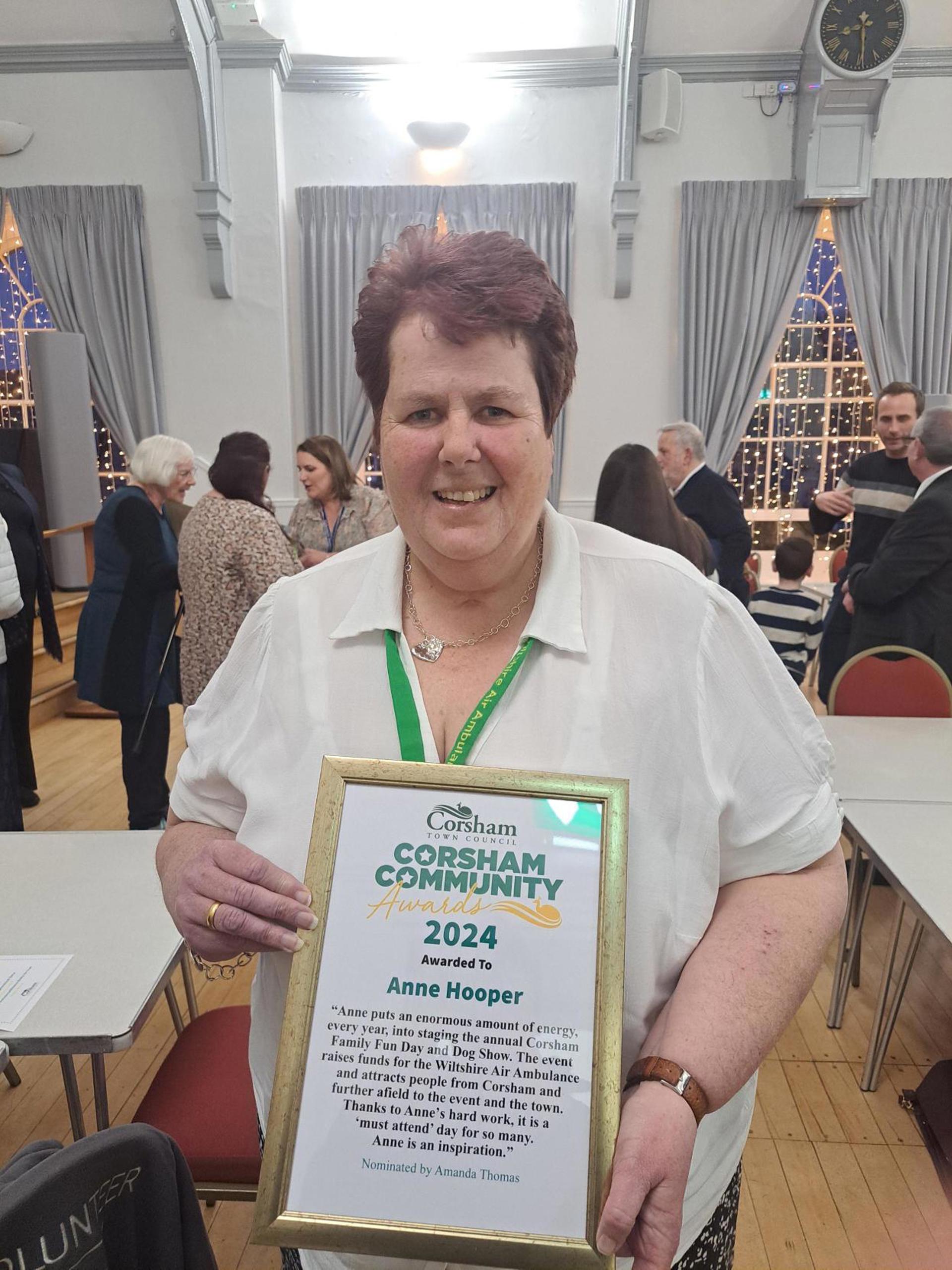 A lady holding a certificate in gold frame