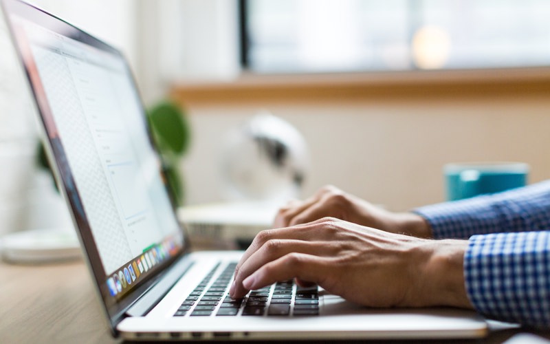 A person using a laptop on a desk