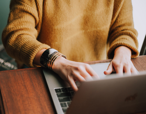 A person typing on a laptop and the option to find out more information about getting your will for free online