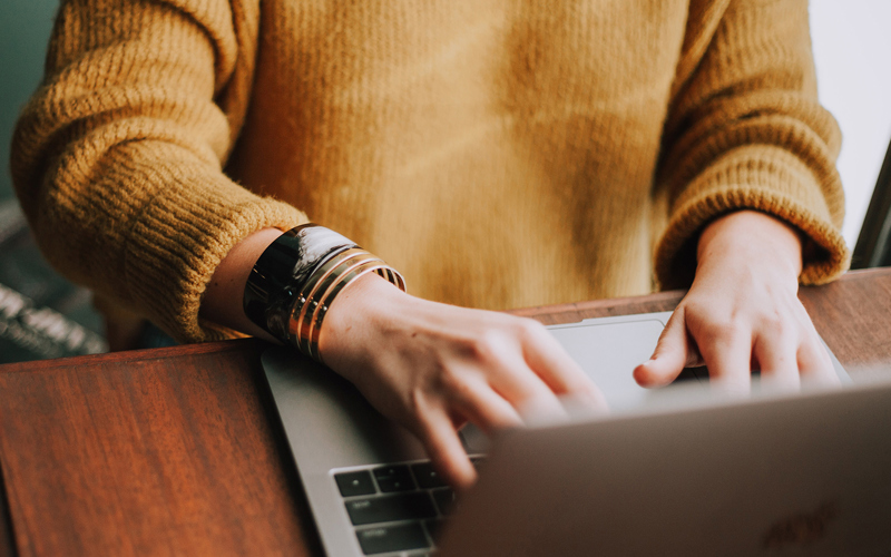 A person typing on a laptop and the option to find out more information about getting your will for free online